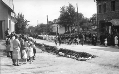 Slavnostní průvod sokolů roku 1930. Na fotografii je možné vidět dům čp. 436 ve výstavbě. V levo od něj stojí kaple Panny Marie, která bude později obestavěna dalšími patrovými domy.